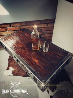 two empty bottles sitting on top of a wooden table next to a cowhide rug