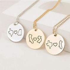 three necklaces with the word love and two states on them