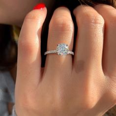 a close up of a person's hand with a diamond ring on their finger