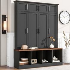 a room with a large black cabinet next to a wall clock and some bookshelves