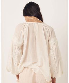 Elegant and sweet, our Magnolia Blouse features intricate details of micro ruffles, lace trims and tassels all crafted on the softest organic cotton. Pair this back with your favourite denim or dress it up with a statement skirt and jewels to take this baby from day to night. Crafted from our preferred fibre 100% organic cotton Shell buttons down front allowing it to be worn as a blouse or open as a shirt Unlined for easy wear 100% Organic Cotton Elasticated Sleeve Cuff Neck Ties Raglan Sleeve P Feminine Cotton Tops With Lace Sleeves, Feminine Cotton Lace Top With Lace Trim, Bohemian Spring Top With Lace Trim, Feminine Cotton Tops With Lace Trim, Chic Cotton Tops With Lace Sleeves, Bohemian Cotton Peasant Top With Lace Trim, Spring Cotton Blouse With Crochet Trim, Elegant Ruffled Tops For Gatherings, Feminine Cotton Tops With Crochet Trim