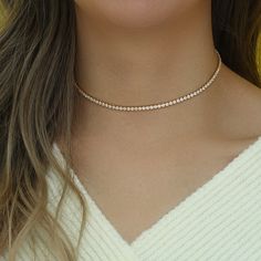 Introducing the Cristal Choker, a dazzling and sophisticated accessory that is sure to turn heads. This stunning choker features a beautiful Cristal Rhinestone design, which adds a touch of glamour and elegance to any outfit. Crafted with high-quality materials, this choker is made with stainless steel and plated with 14k gold, giving it a beautiful and long-lasting shine. Its tarnish and water-resistant properties make it the perfect accessory for daily wear, ensuring that it will maintain its Formal Tennis Necklace With Rhinestones, Diamond White Diamond Necklace With Rhinestones, Elegant Rhinestone Tennis Necklace Gift, Elegant Rose Gold Crystal Necklaces For Party, Elegant Rose Gold Rhinestone Necklace For Party, Elegant Rose Gold Crystal Necklace For Parties, Elegant Gold Tennis Necklace With Rhinestones, Diamond White Necklaces For Party, Diamond White Rhinestone Necklace With Diamond Accents