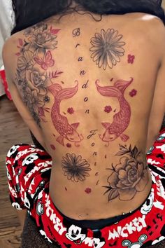 the back of a woman's body with tattoos on it