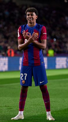 a man standing on top of a soccer field holding his hands in front of him