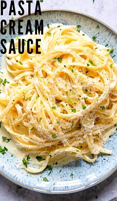 pasta with cream sauce on a blue and white plate next to a sign that says pasta cream sauce