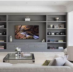 a living room filled with furniture and a flat screen tv mounted on a wall above a fireplace