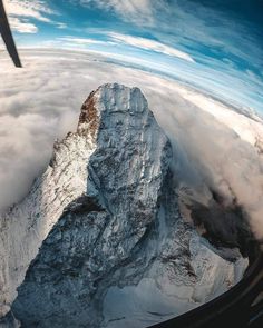 the view from an airplane looking down at mountains and clouds