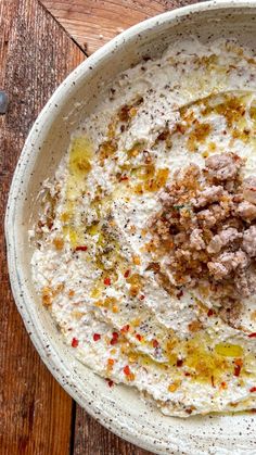 a white bowl filled with food on top of a wooden table