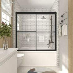 a bathroom with a toilet, shower and bathtub next to a white tiled wall