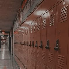 rows of lockers lined up along the wall in a hallway with lights on them