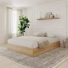 a bedroom with a bed, plant and rug on the floor in front of it