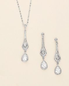 Complete your bridal look with this stunning wedding jewelry set. The sparkling cubic zirconia stones delicately accentuate the bride's natural beauty, adding a touch of elegance and glamor. Featuring an art deco style design, this bridal jewelry set features CZ teardrops accented with a filigree pattern. DETAILS * High quality cubic zirconia.  * Earrings measure 2 inches long. * Necklace is adjustable from 16 inches to 18 inches long, pendant (including bail) measures 2 inches. * Perfect for brides, bridesmaids, prom, or any special occasion. Optional custom cards available for gift giving! * Optional bracelet measures 7 inches long. * Finish: silver, gold or rose gold. * Hypoallergenic, lead-free & nickel-free. SHIPPING * Leaves our facility within 1-3 business days. * Shipping upgrades Elegant White Jewelry Sets For Brides, Wedding Jewelry Sets In White Gold With Diamond Accents, Wedding Jewelry Sets In Diamond White With Brilliant Cut, Diamond White Brilliant Cut Jewelry Sets For Wedding, Brilliant Cut Diamond White Jewelry Sets For Wedding, Dazzling Diamond-accented Jewelry Sets For Wedding, Wedding Jewelry Sets With Sparkling Cubic Zirconia, Elegant Crystal Bridal Sets For Bride, Dazzling Diamond Accented Jewelry Sets For Wedding