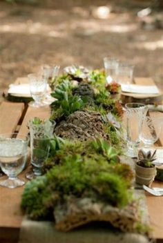 the table is covered with moss and wine glasses