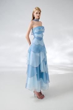 The dress is expertly designed with a classic straight neck and layered organza material, creating an elegant ankle-length silhouette. Perfect for formal occasions, this dress exudes sophistication and timeless style. *Product length is measured from the shoulder to the hem. Ethereal Dress Blue, Gorgeous Dresses Elegant, Something Blue Outfit, Gown Neck Design, Organza Dress Styles, Blue Gowns Elegant, Blue Runway Dress, Light Blue Outfit Ideas, Prom Blue Dress