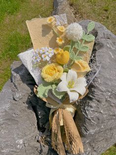 a bouquet of flowers sitting on top of a rock