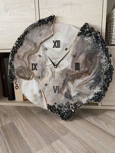 a clock made out of an oyster shell with roman numerals on the face