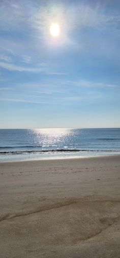 the sun is shining over the ocean and beach