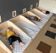 three children are sleeping on their beds in the room