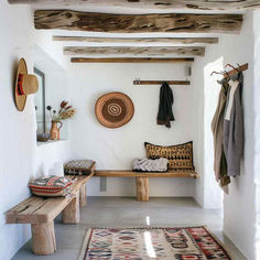 a room with a bench, rugs and other items on the wall next to it