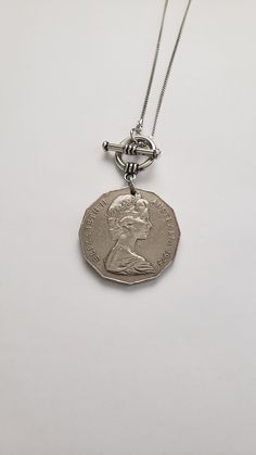 "For your favorite Australian, this necklace will be a treasure! It features a 1975 Australian 50-cent coin with the image of Queen Elizabeth on one side and an emu and kangaroo on the reverse side. The coin dangles from a 16\" silver-tone chain with a front toggle closure that enhances the overall look of this necklace. Welcome to Recycled Finery!  I repurpose old jewelry, coins, beads, vintage buttons, watch parts, and charms into new jewelry.  My ever-growing collection of these materials comes from estate sales, rummage sales, antique and thrift stores, and family and friends' collections they no longer need or want. I have fun putting these new pieces together and hope that you will find them fun to wear and as unique gifts for your loved ones.  Thank you for your interest and purchas Vintage Metal Coin Necklace With Round Pendant, Toggle Necklace With Coin Pendant, Vintage Sterling Silver Charm Necklace With Lobster Clasp, Vintage Sterling Silver Medallion Necklace Gift, Vintage Sterling Silver Medallion Necklace For Gift, Vintage Adjustable Coin Necklace, Silver Nickel-free Toggle Necklace For Gift, Silver Toggle Necklace Nickel Free Gift, Vintage Sterling Silver Medallion Necklace With Coin Pendant