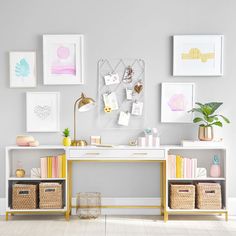 a white desk with baskets and pictures on the wall