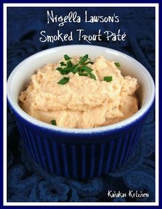 a blue bowl filled with mashed potatoes and garnished with parsley on top