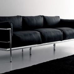 a black couch sitting on top of a white floor