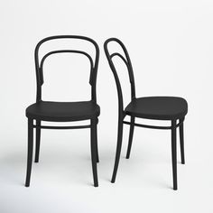 two black chairs sitting next to each other on a white surface with no one in it