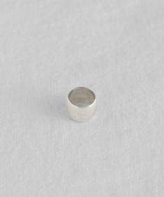 a silver ring sitting on top of a white surface