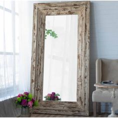 a large mirror sitting next to a chair in a room