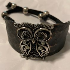 Heavy Metal Black/Copper Wide Band Bracelet. The Owl Is Silver Metal With Black Glossy Bead Eyes That Are Raised. Crystals Imbedded In The Owls Breast Shine Giving The Bracelet A Sparkling Effect. The Leather Cord Is Adjustable By Big Silver Metal Beads. It’s A One Of A Kind. 4” Adjustable Cord Nwot Adjustable Gunmetal Metal Bracelet, Adjustable Gunmetal Metal Bracelets, Adjustable Gunmetal Bracelet, Adjustable Metal Beaded Bracelets, Costume Jewelry, Elegant Metal Beaded Bracelets For Festivals, Adjustable Gunmetal Beaded Jewelry, Nickel-free Metal Bracelets For Festivals, Adjustable Beaded Gunmetal Jewelry, Black Metal Bracelets For Festivals