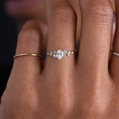 a woman's hand with three diamond rings on her left and the middle finger