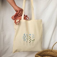 "Beautiful and elegant handpainted cottagecore blue tote bag. It's an ideal shopping bag, for your books and even a nice fashion bag for the whole year . In addition, it is very comfortable because of its long handles and many things fit :) 38 cm x 41 cm (14,96\" x 16,14\") The tote bags hold approximately 22.05 lbs (10 kg). I tell you how I painted it: First, I wash the cloth bag. This is how I get the final size of the bag (you will not be surprised when washing it because it already has its f Easy Tote Bag Design, Tote Bag Painting Ideas Flowers, Cute Tote Bag Design Paint, Flower Tote Bag Design, Tote Bag Diy Paint, Tote Bag Inspo Paint, Handpainted Totebag, Tote Bag Flower Design, Tote Bags Painting