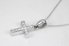 A token of faith. An 18k white gold cross showcases 11 stunning, princess cut diamonds, channel set. Each diamond is near colorless with 100% clean eye clarity. This pendant is a perfect size, not too small but big enough to be noticed and adored. This gorgeous diamond cross necklace is perfect for everyday use. It is an ideal gift to oneself or to someone you love! An inch 18K white gold cable chain is included with this diamond cross. Metal Purity: 18K White Gold (stamped behind bale: 18K) Set White Cubic Zirconia Crucifix Jewelry, Diamond White Diamond Cross Necklace For Anniversary, Anniversary Diamond Pendant Cross Necklace, Diamond Pendant Cross Necklace For Anniversary, Silver Cross Jewelry With Brilliant Cut, White Gold Cubic Zirconia Cross Necklace For Anniversary, Brilliant Cut Cubic Zirconia Cross Necklace As Gift, Anniversary White Gold Cubic Zirconia Cross Necklace, White Gold Crucifix Jewelry With Cubic Zirconia