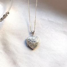 This silver heart locket is inspired by the romance of a by-gone era. Made in sterling silver 925, the locket is crafted with an intricate detailed leaf design.  Hinged, it opens so you can keep your treasured photos close to your heart.  A thoroughly thoughtful gift for a special woman, this gorgeous silver heart-shaped locket is destined to be cherished eternally. Available with different length silver chains. Measures  Width: 19 mm.  Height: 26 mm. Antique Silver Sterling Silver Locket Pendant Necklace, Heirloom Silver Heart Pendant Jewelry, Classic Silver Heart Locket Necklace, Classic Heart Shaped Sterling Silver Locket Necklace, Classic Sterling Silver Heart Locket Necklace, Classic Heart-shaped Sterling Silver Locket Necklace, Silver Open Heart Locket Necklace With Heart Charm, Sterling Silver White Gold Heart Charm Locket Necklace, Heart Shaped Hallmarked Silver Locket Necklace