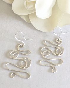 "These one of a kind earrings feature an abstract design of loops and twists that have been gently hammered to give more dimension and texture. Choose sterling silver or silver plated ear wires from the drop down menu. They measure approximately 2\" from the ear wires." Hammered Drop Wrap Earrings As A Gift, Hammered Drop Wrap Earrings For Gift, Modern Twist Dangle Earrings For Gift, Modern Twist Dangle Earrings As Gift, Handmade Earrings With A Modern Twist As A Gift, Modern Twist Metal Earrings With Ear Wire, Artsy Silver Earrings With Ear Wire, Modern Twist Metal Earrings As Gift, Modern Twist Metal Earrings For Gift