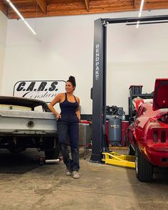 a woman standing next to a car in a garage