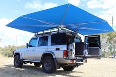 a white truck with a blue awning on the back