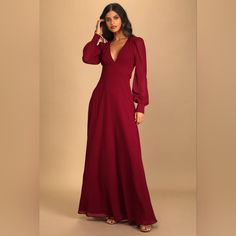 a woman in a long red dress is posing for the camera with her hand on her head