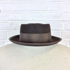 Size 6 7/8 Vintage 1950s 1960s Adam Hats Carbon Brown Porkpie Fedora Hat For your consideration we have a vintage fedora from the ‘50s/‘60s. Made by Adam Hats from a “carbon brown” fur felt, this “Rugby” model features a telescopic crown, brown grosgrain band and edge, leather sweatband, and rayon lining. There are a few spots on the hat band and a few stitches have come out of the leather sweatband. This is still a great hat and wonderful for anyone into slick bop midcentury style.Measurements; Fitted Brown Hat For Kentucky Derby, Formal Brown Brimmed Hat, Fitted Vintage Brown Panama Hat, Vintage Fitted Brown Panama Hat, Fitted Brown Top Hat With Flat Brim, Brown Fitted Top Hat With Flat Brim, Vintage Fedora With Flat Crown, Brown Fitted Fedora For Kentucky Derby, Fitted Brown Panama Hat With Flat Crown