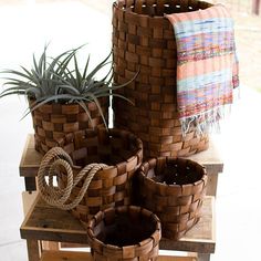 several woven baskets with plants in them on a table