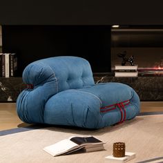 a blue recliner chair sitting on top of a rug next to a remote control