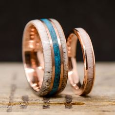 two wedding bands made out of copper, turquoise and white marbles are sitting on top of each other