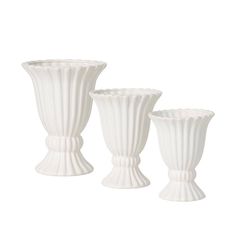 three white vases sitting next to each other