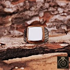 a gold and white ring sitting on top of a rock