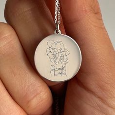 Create a one-of-a-kind treasure with our custom line art jewelry. Transform your cherished photo into a unique piece of art that you can wear close to your heart. Our skilled artists will create line art based on your provided photo, capturing the essence of your special memory. The artwork is then laser-engraved onto the pendant and hand-finished to perfection. Customize your pendant further by choosing a heartfelt text to engrave, tailored to the occasion. We'll send you a preview of your order to confirm the chosen design. This unique keepsake is ideal for commemorating birthdays, anniversaries, or any significant event. Create a beautiful tribute that will be cherished forever. Specification: Material: 14K pure Gold or 925 Sterling Silver Dimensions: 20 mm charm; 45 cm chain length *TH Customizable Heart Pendant Necklace For Gift, Artistic Jewelry For Valentine's Day Gift, Engraved Custom Necklace For Valentine's Day Gift, Valentine's Day Engraved Custom Necklace Gift, Valentine's Day Gift Engraved Custom Necklace, Artistic Personalized Necklace, Artistic Personalized Round Necklace, Artistic Personalized Round Pendant Necklace, Artistic Engraved Round Pendant Necklaces