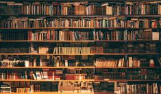 a bookshelf filled with lots of books on top of wooden shelves