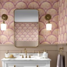 a bathroom with pink and gold wallpaper, two sinks and a large mirror on the wall