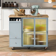 a kitchen cart with baskets on it in front of a counter top and cabinets behind it