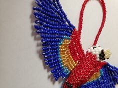 a beaded bird ornament hanging on a wall